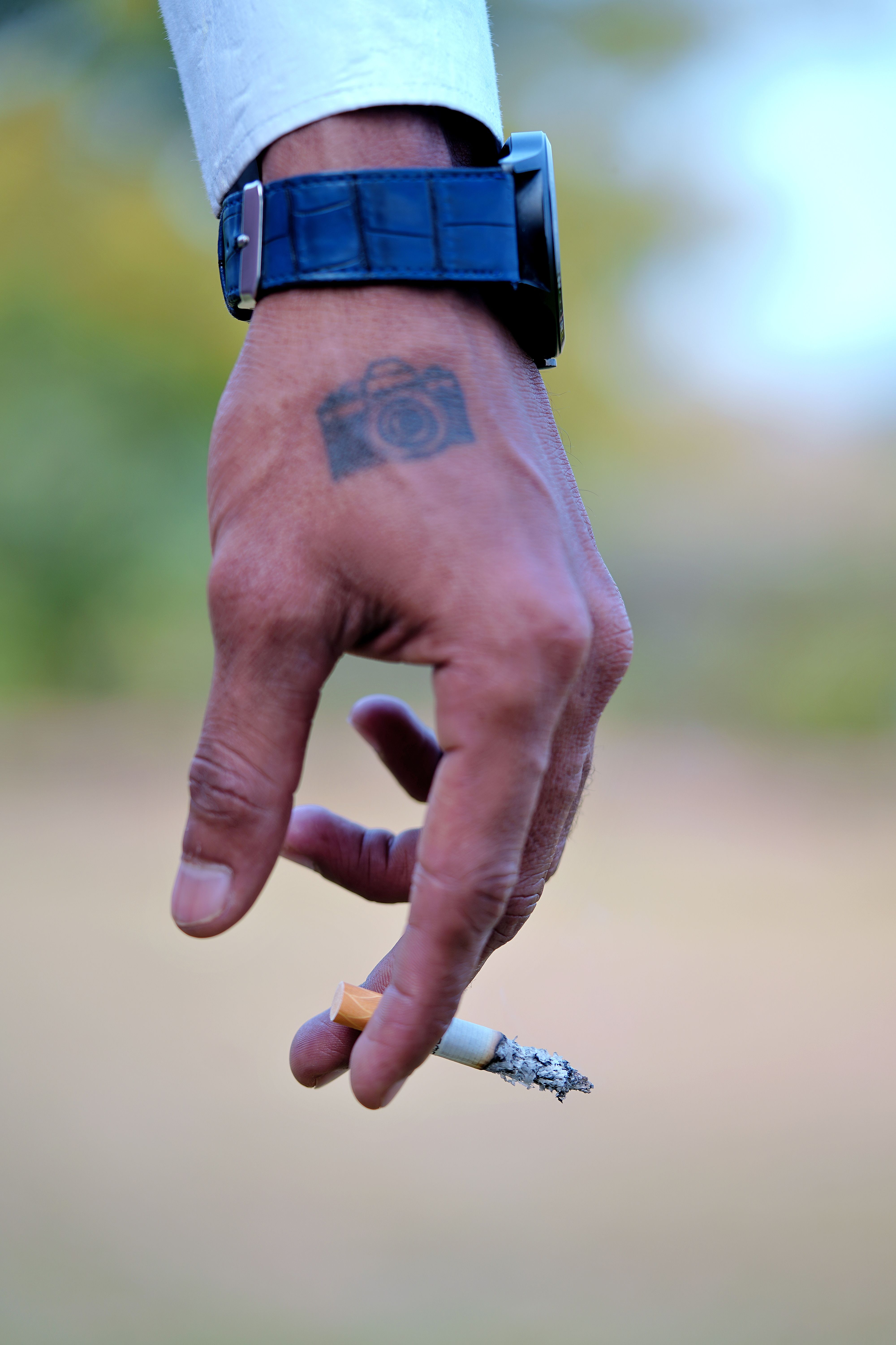 Tatuagem de câmera fotográfica no dorso da mão